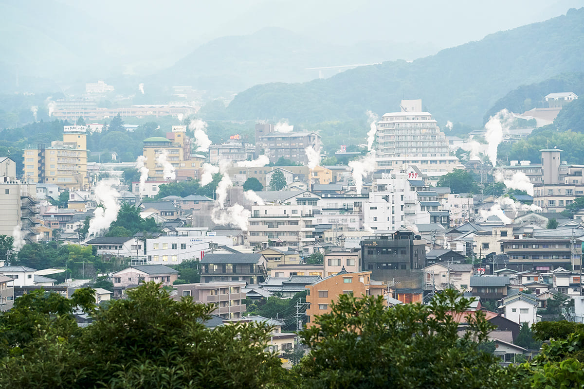 もくもくと漂う煙が味わい深い温泉街の眺め。若い世代にも別府温泉の認知度を広めたいということから、バスクリン社と大分県別府市、同市旅館ホテル連合組合が共同開発した新しい入浴剤「日本の名湯 別府」も発表したばかり。